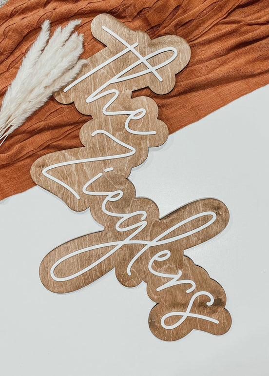 The Zieglers layered family-name sign lying on a pale surface beside orange fabric.