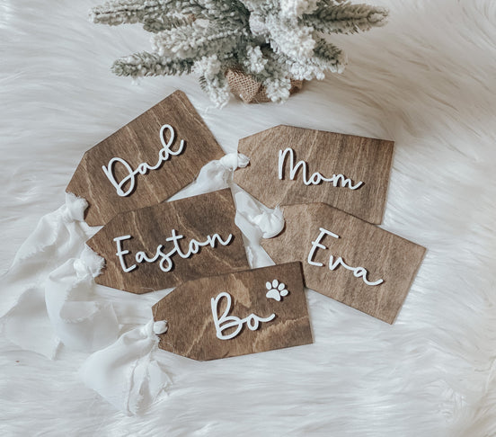 Dark wooden rectangular tags with white Dad, Mom, Easton, Eva and Bo lettering and white ribbon ties.