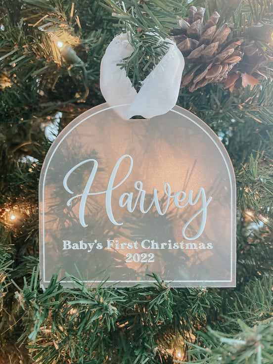 Personalized Harvey Baby's First Christmas 2022 clear ornament hanging on a Christmas tree.