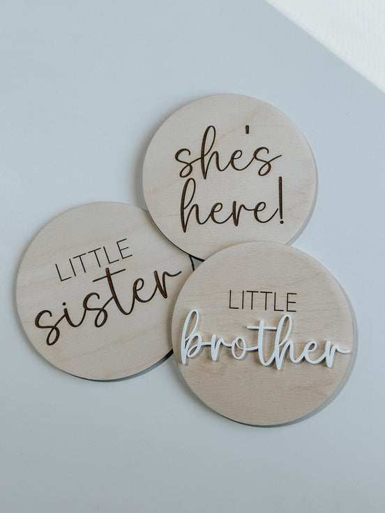 She's Here, Little Sister and Little Brother wooden announcement discs, including raised white script.