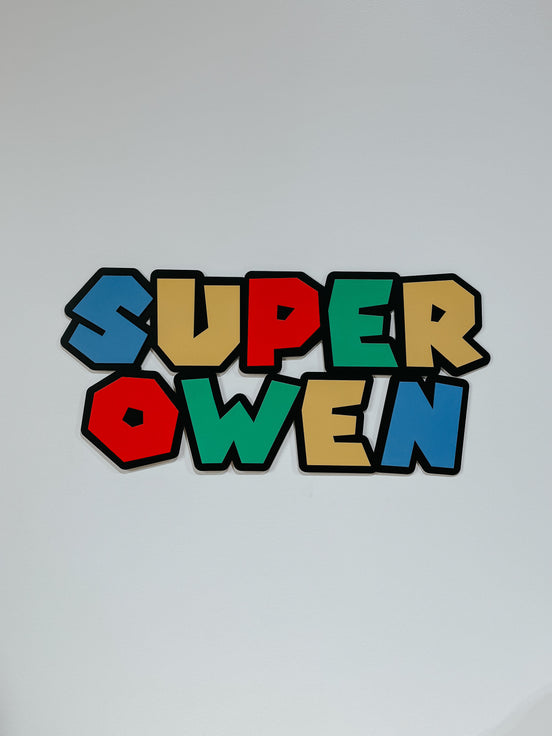 Multicolored Super Owen game-inspired name sign with a thick black outline.