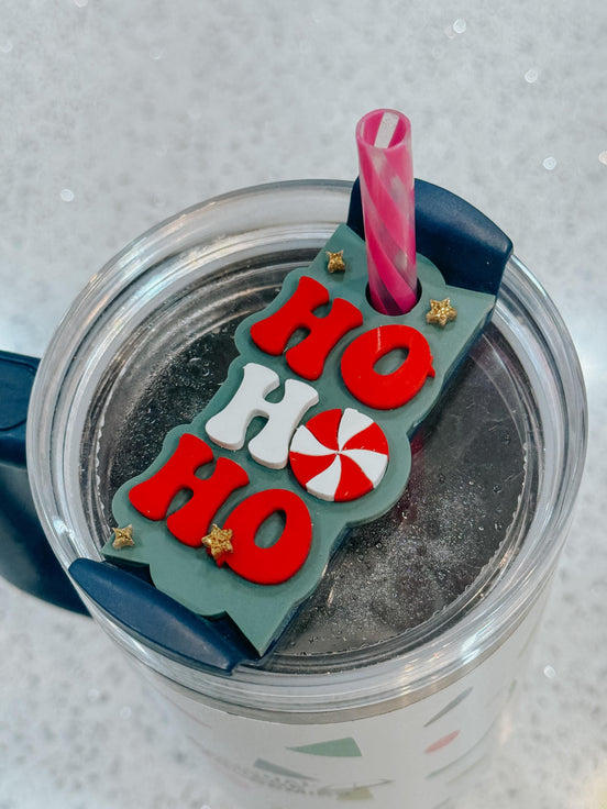 Green Ho Ho Ho tumbler topper with red and white letters, a peppermint accent and small stars.