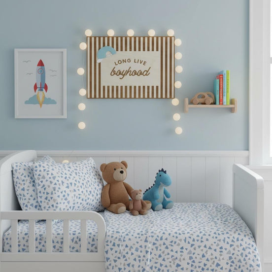 Long Live Boyhood sign displayed above a child's bed with soft lights, toys and shelves.