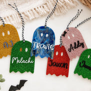 Personalized glitter and marble ghost tags in gold, blue, pink, green and red with hanging cords.